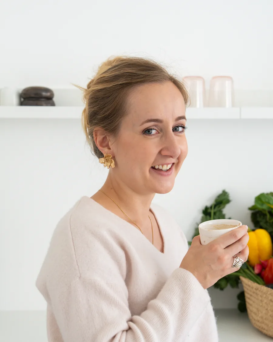 Jelina Linder mit einer Tasse, daneben ein Korb mit frischem Gemüse
